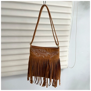 Detalle del bolso de ante marrón con bordados y flecos largos de estilo retro