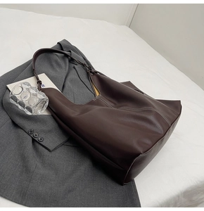 Détail du sac Hobo marron foncé avec surpiqûres blanches et texture en cuir lisse élégant