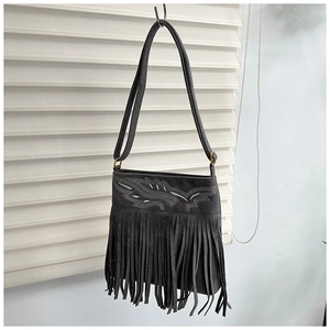 Detalle del bolso bandolera de ante con flecos largos y bordados étnicos