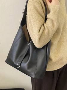 Grand sac cabas noir en cuir souple avec anneau argenté et design d'épaule minimaliste