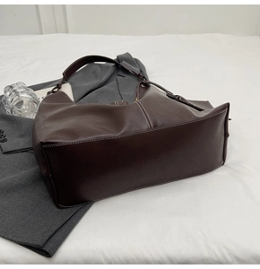 Détail du grand sac cabas marron foncé avec coutures blanches contrastées sur cuir mat