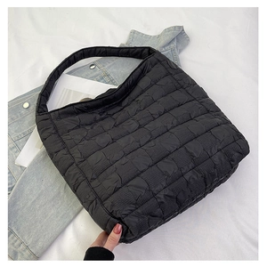 Detailed macro view of the black quilted bubble texture on a large puffy tote bag