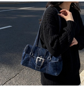 Détail du sac à bandoulière en denim lavé bleu avec boucle argentée et bretelles