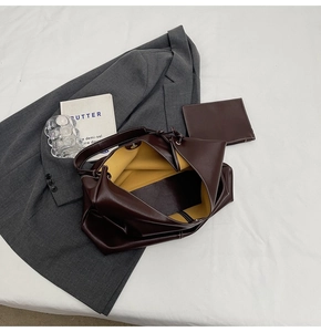 Détail d'un sac cabas en cuir marron avec doublure jaune et petit sac à main assorti