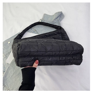 Close-up of black quilted cloud bag showing puffed square texture and nylon material