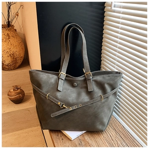 Detail van grijze matte shopper met decoratieve gesp en verstelbare schouderriem
