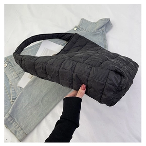 Detail shot of black quilted cloud tote bag featuring unique pleated nylon texture
