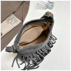 Detalle del bolso de ante gris con flecos mostrando el forro y bolsillo interno
