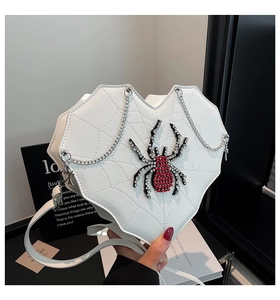 Detail der weißen Herz-Tasche mit 3D-Strass-Spinne und Spinnennetz-Stickerei