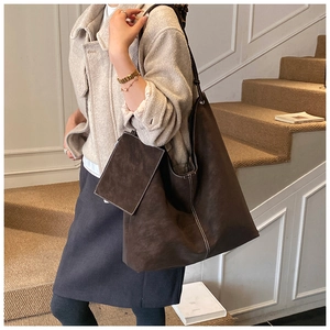 Detail view of large dark brown tote bag with contrast stitching and matching pouch