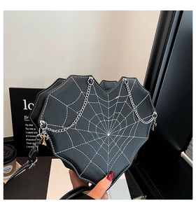Detail der herzförmigen Handtasche mit Spinnennetznaht und Kreuzanhängerkette