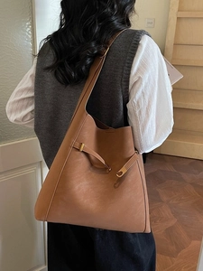 Caramel brown large capacity bucket bag with gold hardware and matte leather texture