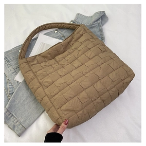 Detail of khaki quilted tote bag with bubble texture and integrated shoulder strap