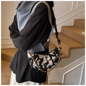 Detail showing jacquard texture and knot shoulder strap of the black and white hobo bag