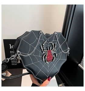 Detail der herzförmigen Gothic-Umhängetasche mit Spinnennetzmuster und Strass-Spinne