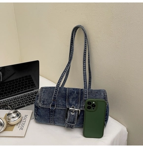 Vue détaillée du sac baguette en jean vintage avec boucle en métal et bandoulière en denim