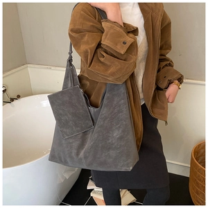 Deep gray frosted suede tote bag with white stitching detail shown on model shoulder