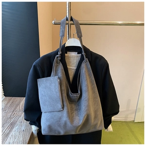 Detail view of large grey microfiber tote bag with matching zipper pouch on jacket