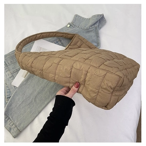 Detailed close-up of brown quilted fabric texture on a large hobo shoulder bag for women