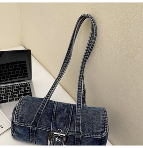 Gros plan du sac porté épaule en denim bleu délavé avec boucle en métal sur bureau