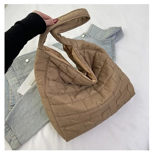 Detail shot of brown quilted puffy tote bag featuring soft textured nylon pleats