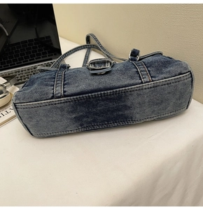 Détail d'un sac à bandoulière en denim délavé avec boucles en métal et coutures nettes