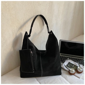 Macro detail of large black suede hobo bag with contrast stitching and inner pouch