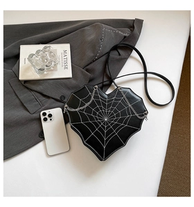 Detail der herzförmigen Handtasche mit weißem Spinnennetz-Stickerei und Silberkette