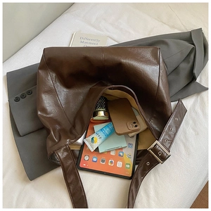 Detailed macro of dark brown leather tote bag with silver adjustable strap buckle