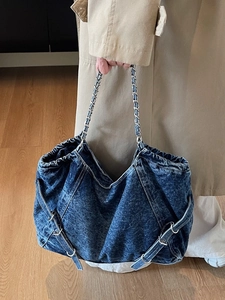 Vintage washed denim tote bag with silver chain strap shown as an oversized shoulder bag