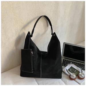 Detail of black tote bag with white contrast stitching and a small zipper pouch