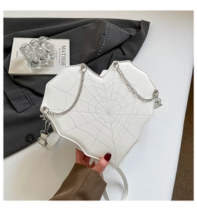 Nahaufnahme der weißen herzförmigen Tasche mit Spinnennetz-Steppung und Metallkette