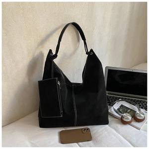 Macro shot of black tote bag featuring white V-shaped stitching and small attached pouch