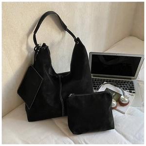 Detailed view of black tote bag set with white contrast stitching on white linen