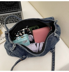Intérieur spacieux du sac en jean bleu montrant la grande capacité pour un ordinateur portable