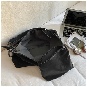 Detail view of black tote bag set with white contrast stitching and inner pouch for commute