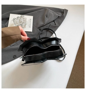 Detail der herzförmigen Handtasche mit weißer Kontrastnaht und silberner Kette