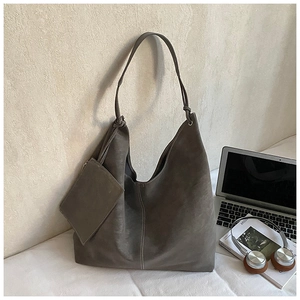 Detail of dark grey suede tote bag with white contrast stitching and a small pouch