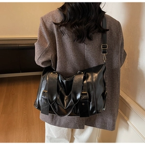 Macro di una grande borsa tote in pelle PU nera lucida con fibbia in metallo e rivetti