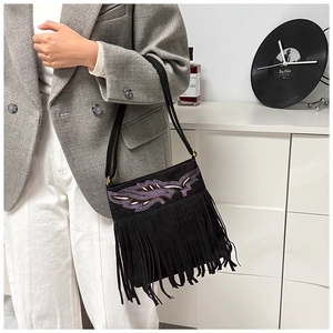 Detalle de bolso bandolera de ante negro con bordado de lentejuelas y flecos largos