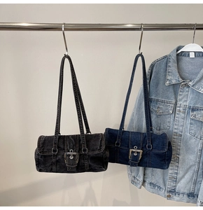 Gros plan de sacs bandoulière en denim délavé noir et bleu avec détails de boucles métal