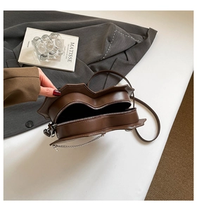Detail der dunkelbraunen herzförmigen Tasche mit Doppelreißverschluss und Lederstruktur
