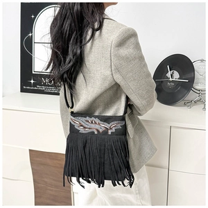 Detalle del bolso bandolera boho de ante negro con bordado de águila y flecos largos