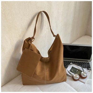 Detail of caramel brown tote bag with contrast white stitching and small pouch