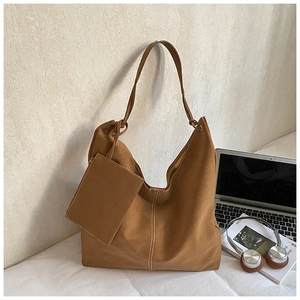 Detailed close-up of tan hobo bag featuring white decorative stitching and matching pouch