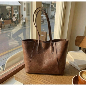 Detailed macro view of vintage brown faux leather texture on the large tote bag surface