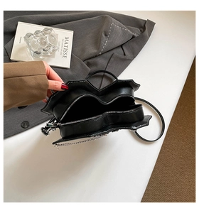 Detail der herzförmigen Handtasche mit Doppelreißverschluss und schicker Silberkette