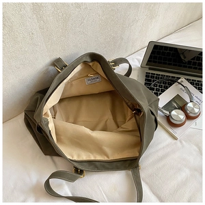 Ruim interieur van de olijfgroene canvas shopper met ritsvak en accessoires