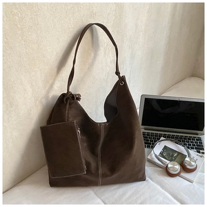 Detail of dark brown suede tote bag featuring white contrast stitching and mini pouch