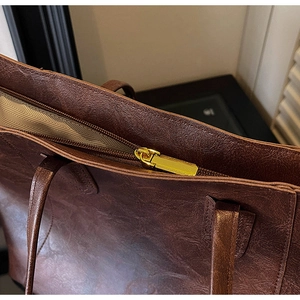 Detail of vintage brown tote bag with gold metal zipper and chevron fabric lining